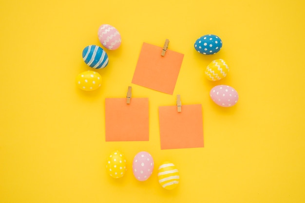Free photo easter eggs with small blank papers on table