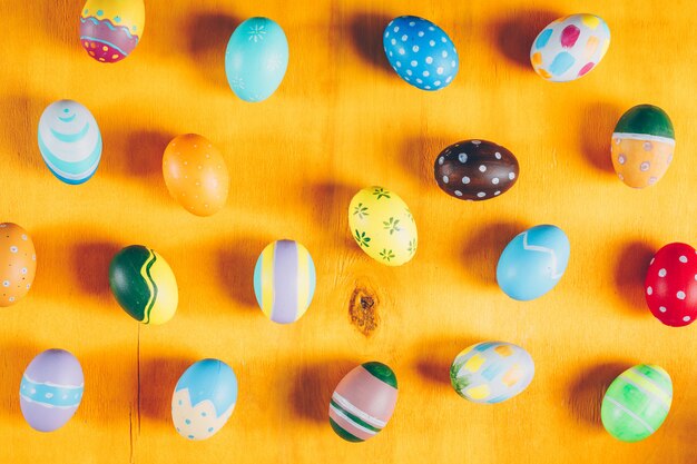 Easter eggs on yellow wooden background.