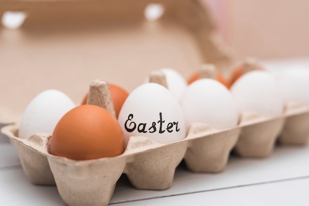 Easter inscription on egg in rack on table