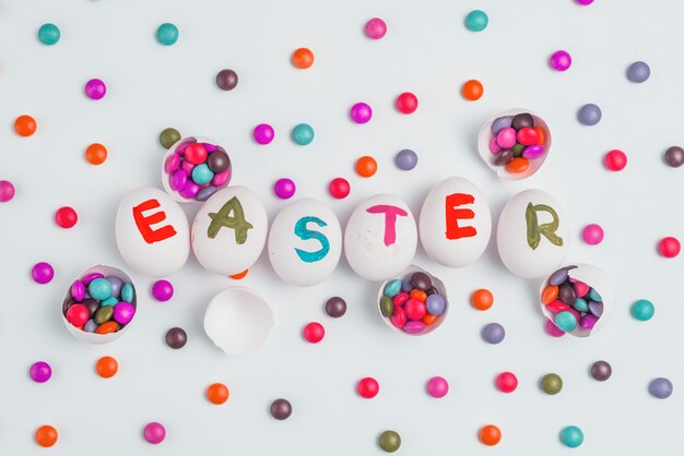 Easter inscription on eggs with candies on table