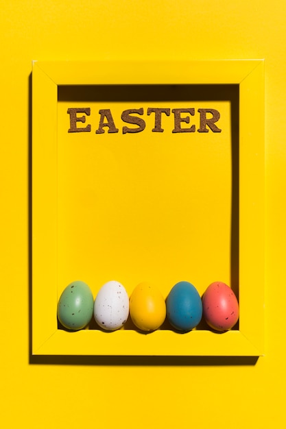 Easter inscription in frame with colourful eggs