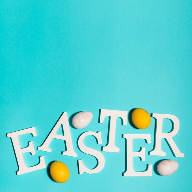 Easter inscription with colourful eggs on blue table