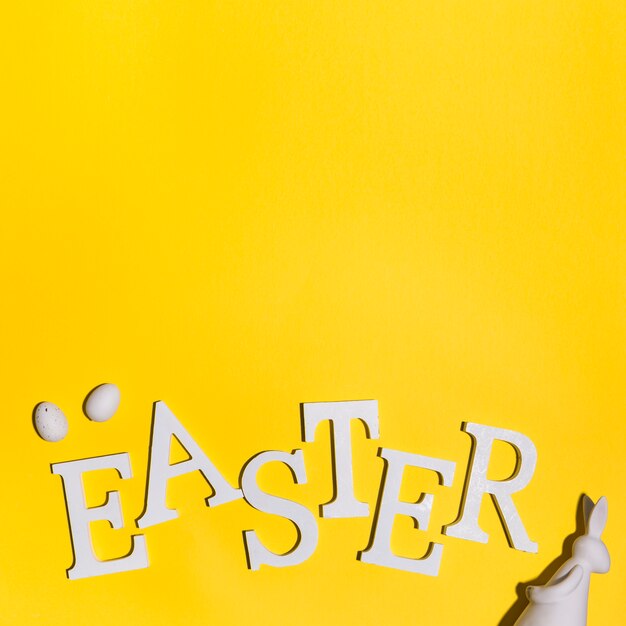 Easter inscription with eggs and rabbit on table