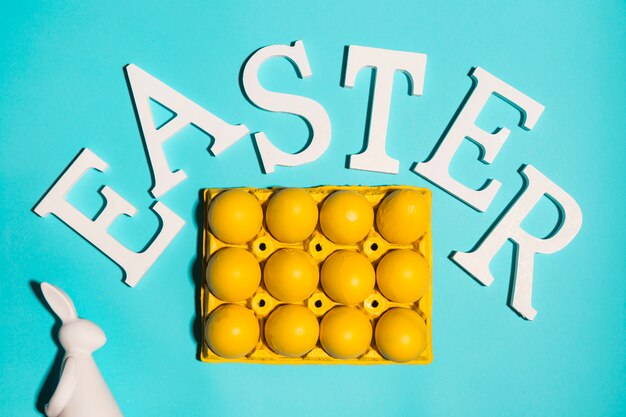 Easter inscription with eggs in rack on table