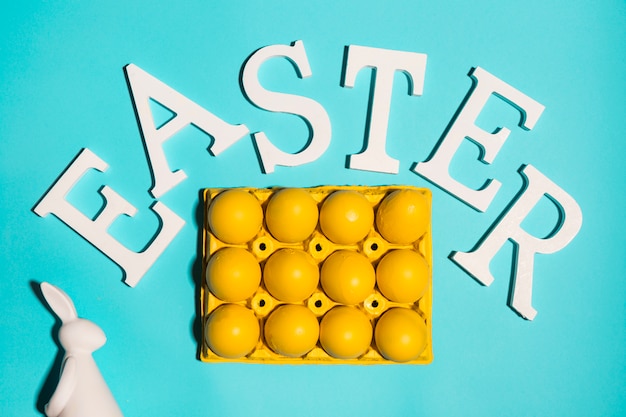 Easter inscription with eggs in rack on table