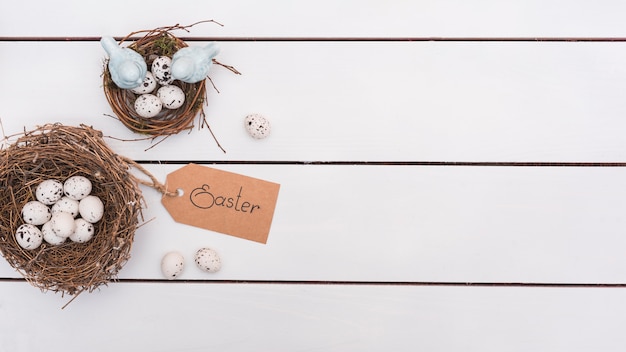 Бесплатное фото Пасхальная надпись с перепелиными яйцами в гнездах