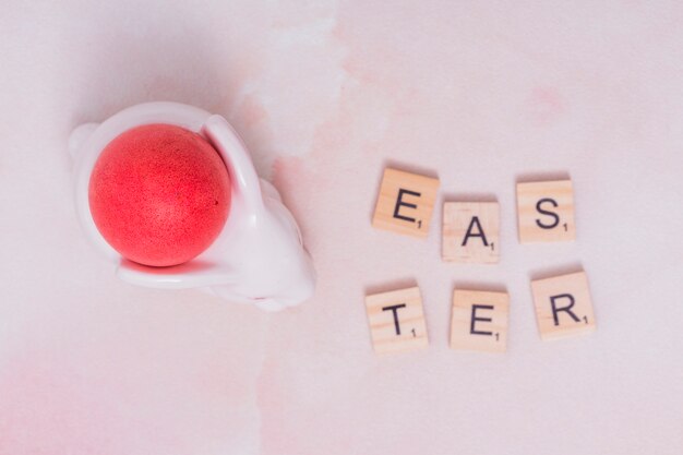 Easter inscription with red egg in cup