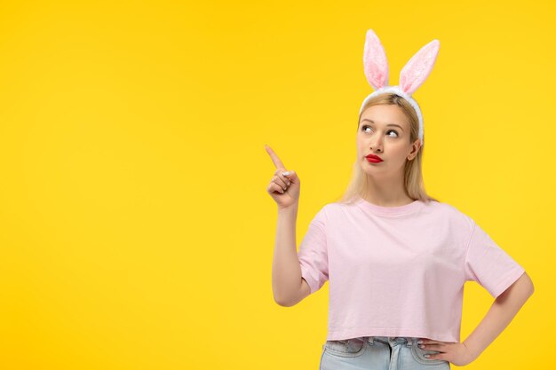 Easter lovely blonde adorable girl with pink bunny ears and red lipstick thinking and looking up