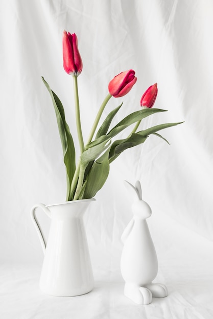 花瓶の花の束の近くのイースターのウサギ