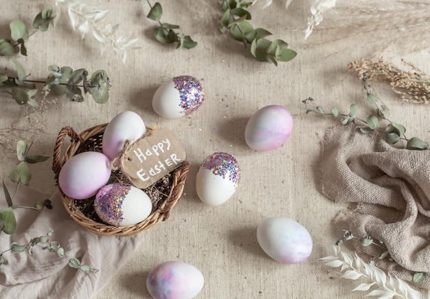 고리 버들 세공 바구니에 장식 조각으로 장식 된 계란 부활절 아직도 인생. 행복 한 부활절 개념