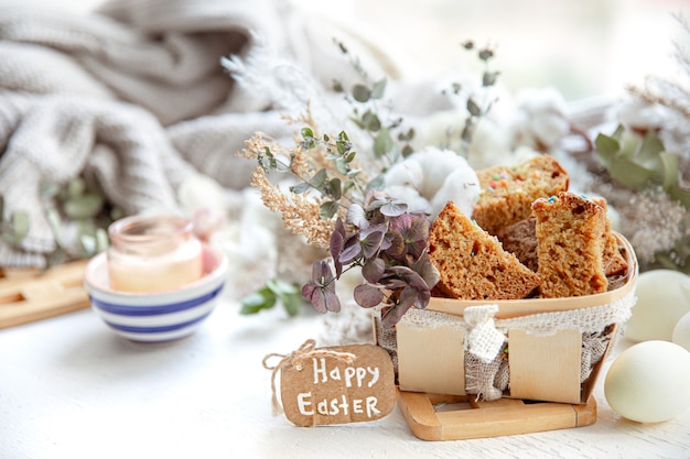 Easter still life with pieces of festive cupcake, eggs and flowers. Easter holiday concept.