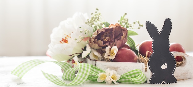 Foto gratuita tavola di pasqua con coniglietto e cestino di pasqua