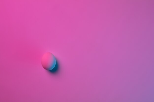 Easter traditions, pink-blue colored eggs on pink background, neon light