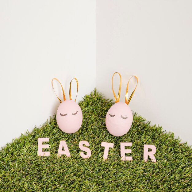 Easter word and cute eggs on grass