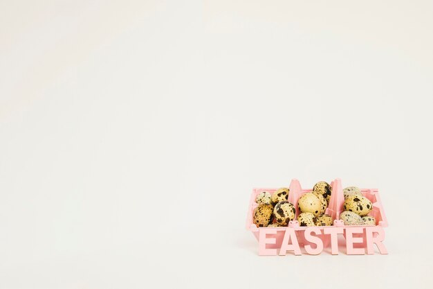 Free photo easter word and quail eggs in rack