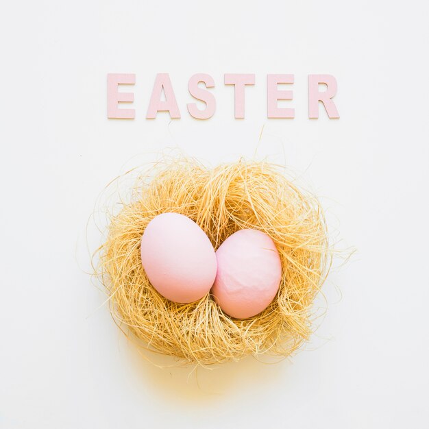 Easter word and two eggs in nest