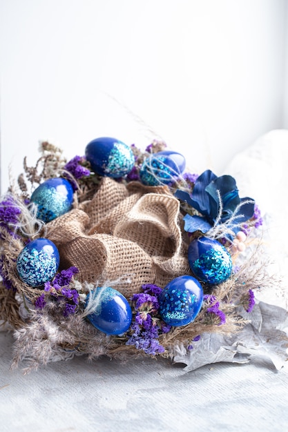 Foto gratuita corona di pasqua con uova blu con paillettes alla finestra.