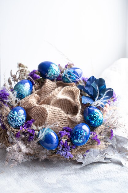 Easter wreath with blue eggs with sequins at the window.