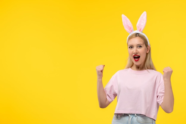 Easter young cute pretty girl with bunny ears excited holding fists up