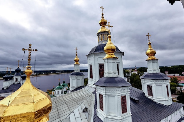Eastern orthodox crosses on gold domes, cupolas, against blue sky with clouds. Orthodox church