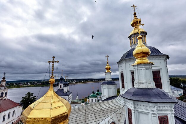 Eastern orthodox crosses on gold domes, cupolas, against blue sky with clouds. Orthodox church