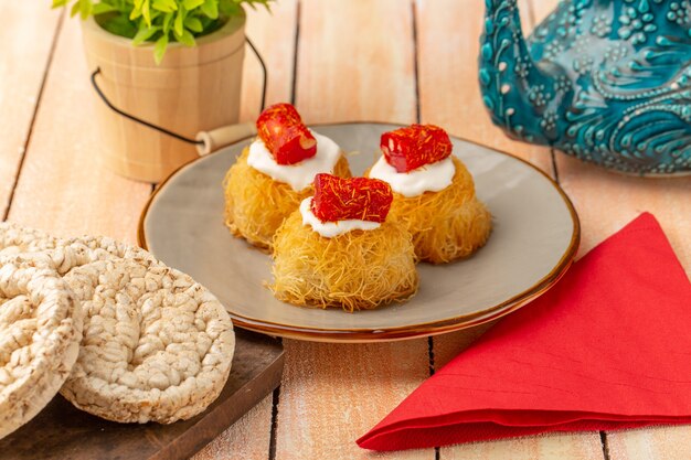 eastern pastry cookies inside plate with white cream and biscuit cookies