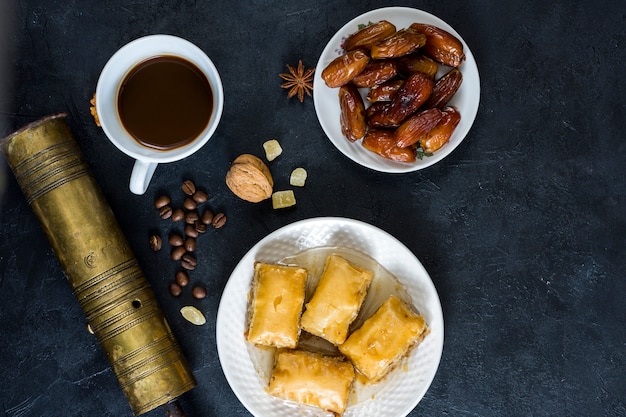 Foto gratuita dolci orientali con frutta data e tazza di caffè