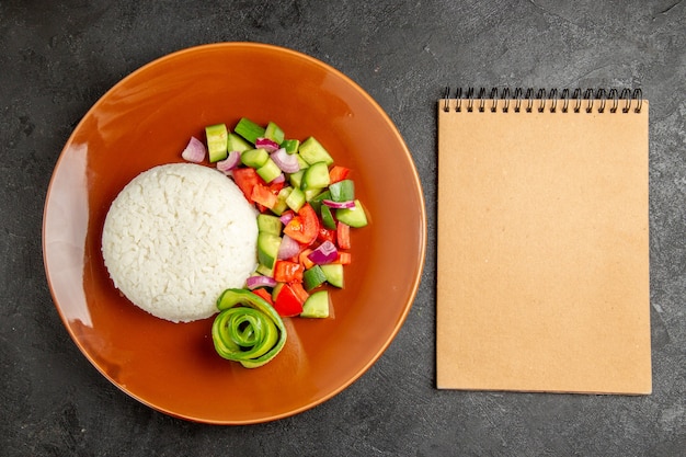 Easy healthy meal and notebook on dark background