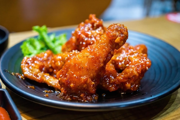 Еда жареной курицы в корейском стиле с острым соусом на тарелке с ложкой и вилкой. концепция еды и напитков.