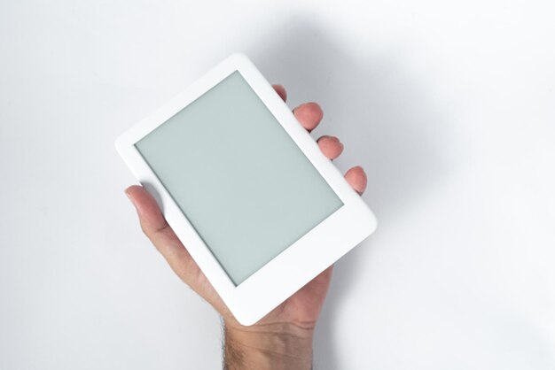 Ebook reader over isolated white background  being held by a male hand