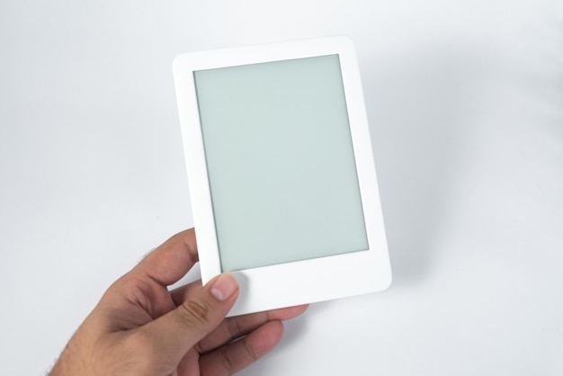 Ebook reader over isolated white background  being held by a male hand