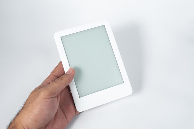 Ebook reader over isolated white background  being held by a male hand