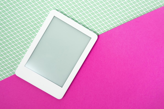 Free photo ebook reader on the striped green background with pink