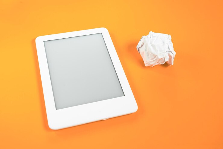 Free Photo ebook reader over yellow background with paper ball beside