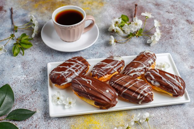 Бесплатное фото Эклеры или профитроли с черным и белым шоколадом с заварным кремом внутри, традиционный французский десерт.