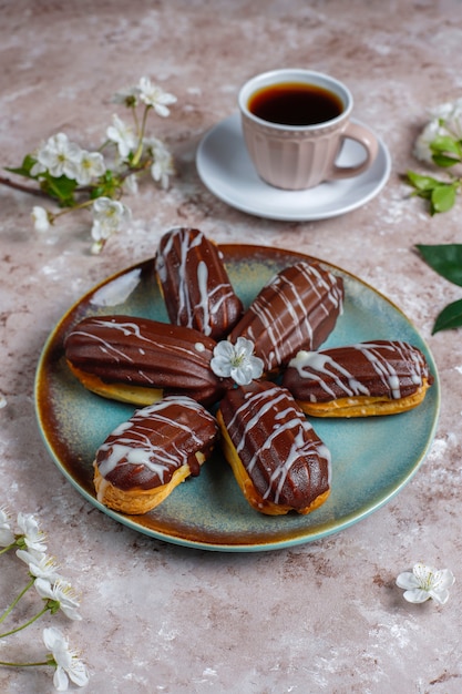 伝統的なフランスのdessert.topビューの内部にカスタードが入ったブラックチョコレートとホワイトチョコレートのエクレアまたはプロフィットロール。