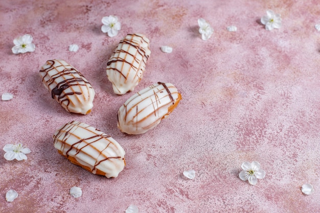 Foto gratuita eclairs o profiteroles con cioccolato nero e cioccolato bianco con crema pasticcera dentro, dessert francese tradizionale vista dall'alto.