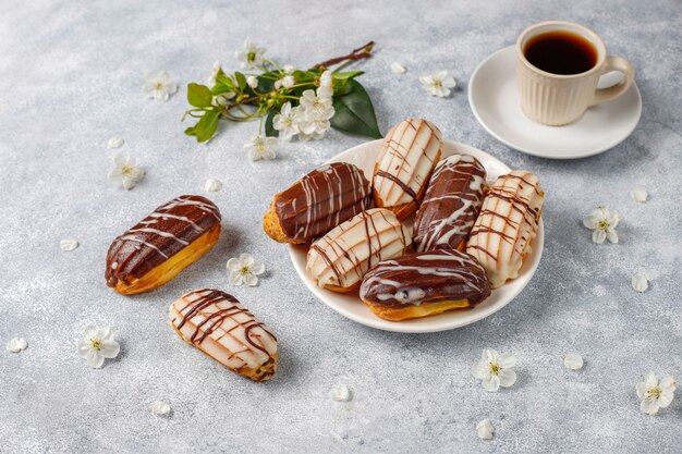 Eclairs or profiteroles with black chocolate and white chocolate with custard inside,traditional french dessert.top view.