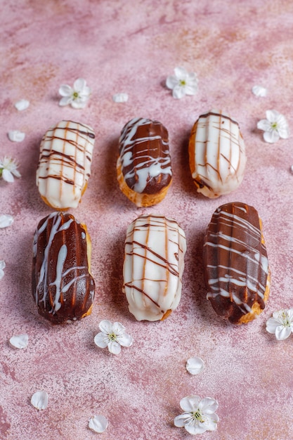 Eclairs or profiteroles with black chocolate and white chocolate with custard inside,traditional french dessert.top view.