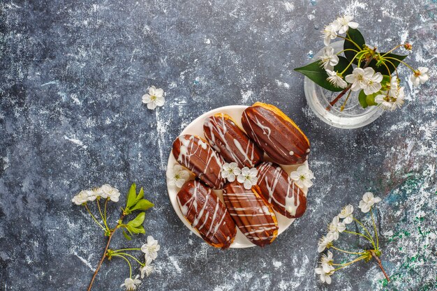 Eclairs or profiteroles with black chocolate and white chocolate with custard inside