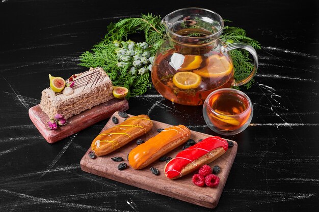 Eclairs on wooden platter with drink.