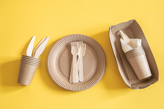 eco friendly disposable dishes made paper on an orange background.