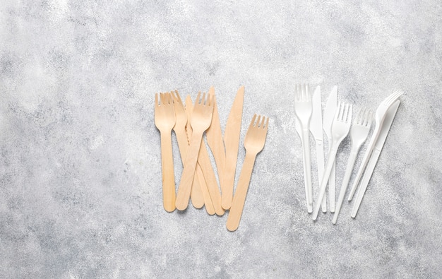 Eco-friendly disposable utensils made of bamboo wood and paper on a blue