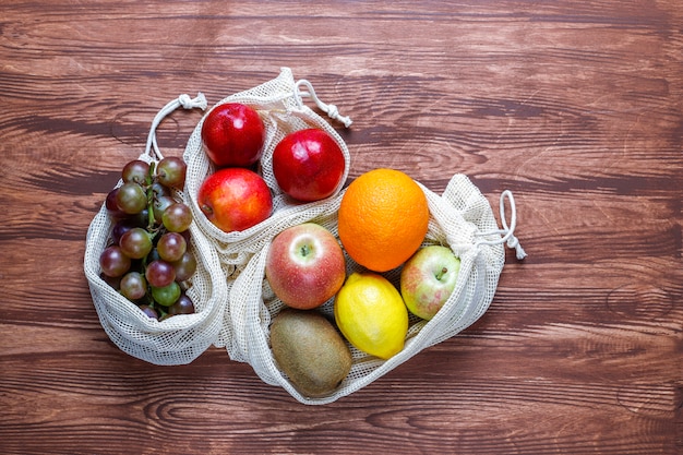 Eco-friendly simple beige cotton shopping bags for buying fruit and vegetables with summer fruits.