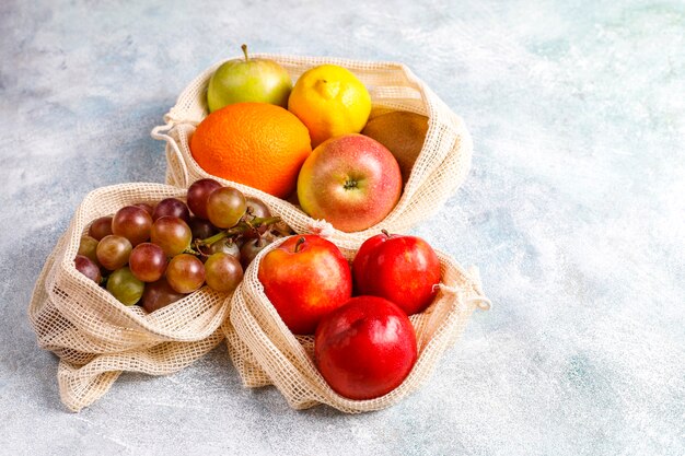 Eco-friendly simple beige cotton shopping bags for buying fruit and vegetables with summer fruits.