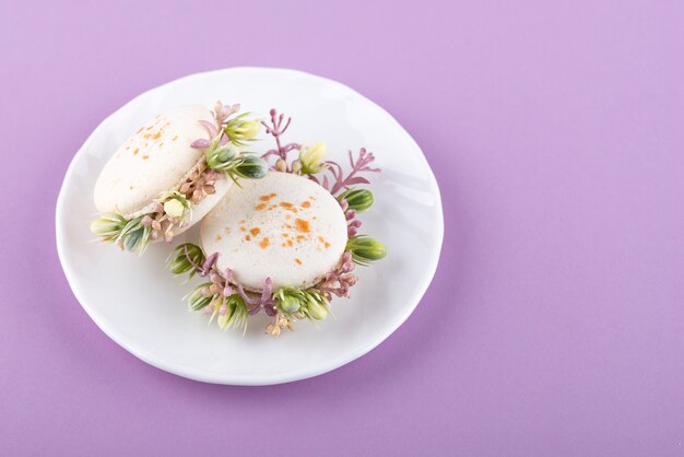 Eco macarons with flowers on plate high angle