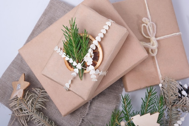 Eco paper bags decorated with ribbons and a dried fir branch ribbons and pine cones
