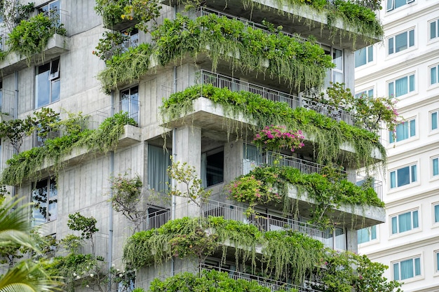 ダナンベトナムの通りの家のファサードの石の壁に緑の植物と花でエコロジカルな建物のファサード Premium写真
