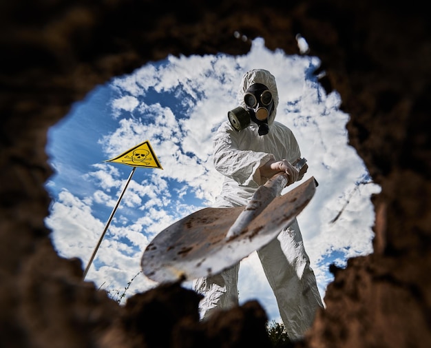 Free photo ecologist digging pit by shovel and planting tree in polluted area