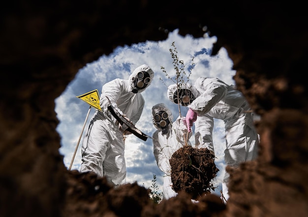 Free photo ecologists digging pit by shovel and planting tree in polluted area